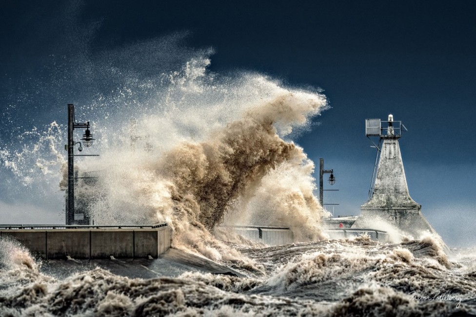 Dramatic waves crashing against a pier