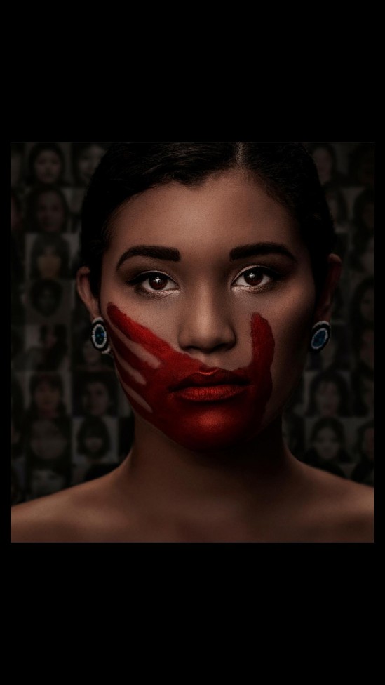 An image of an indigenous woman with a red hand over her mouth