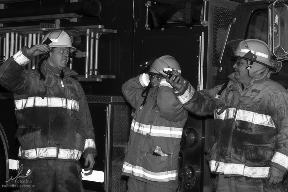 a black and white photo of 3 firefighters