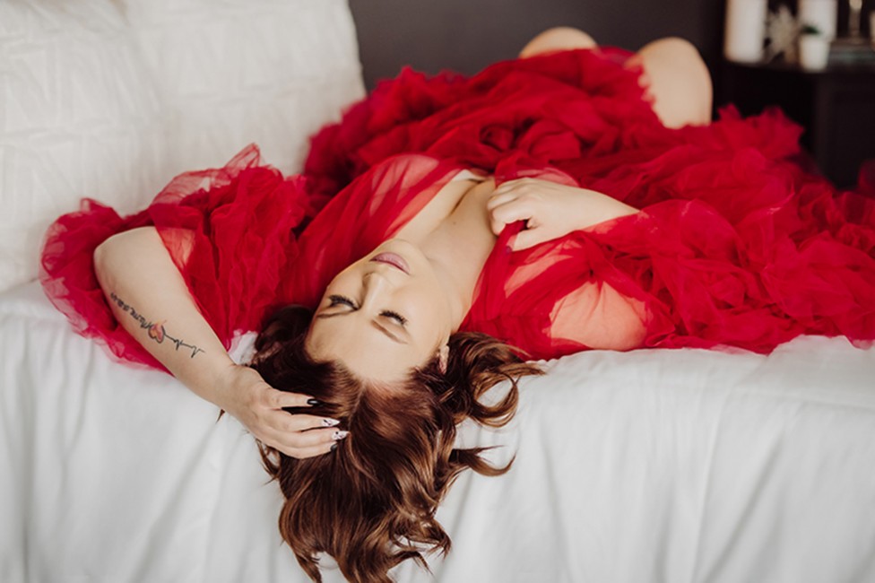 A tasteful boudoir photo of a woman wearing a red negligee