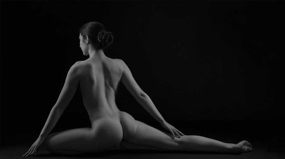 A black and white figure study of a woman from behind