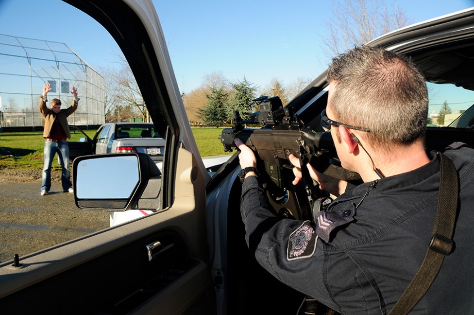 An image of a police officer with his gun drawn, by David James