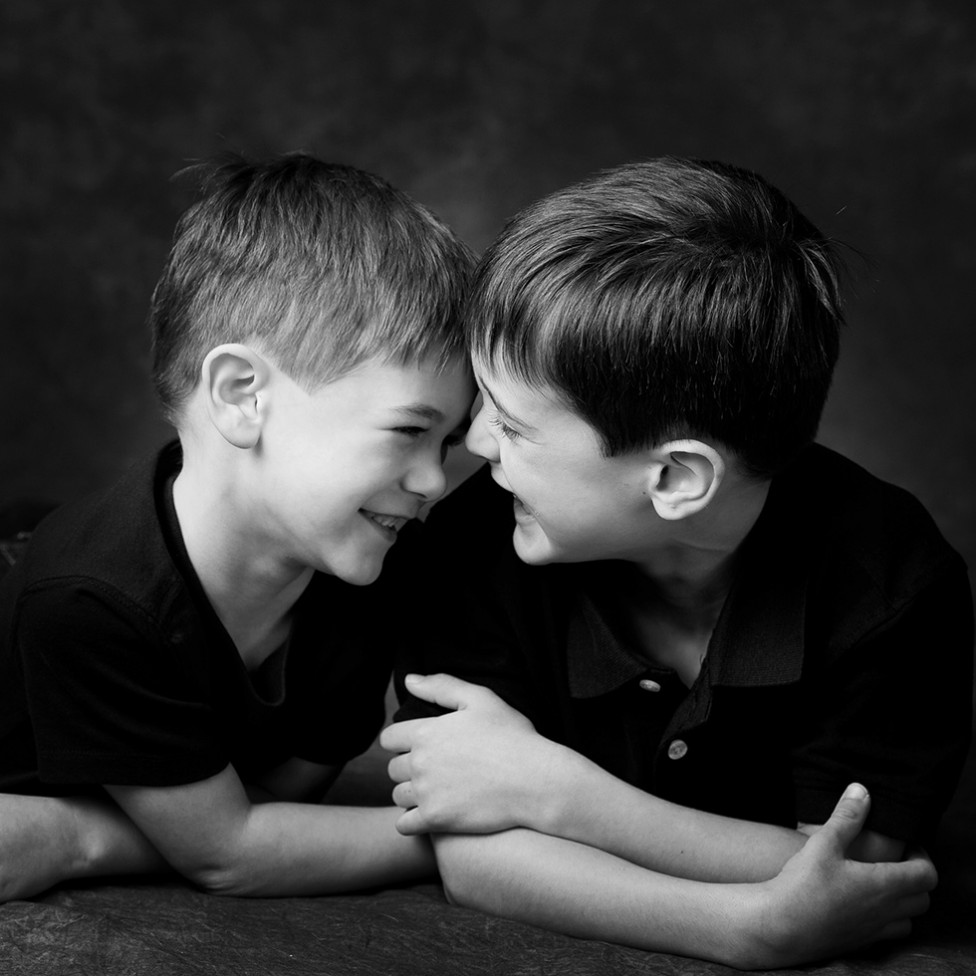 An adorable portrait of two little boys giggling together, by Louise Vessey