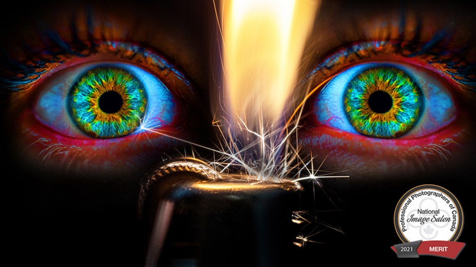 A close up photo of vibrantly coloured eyes and a spark from a lighter
